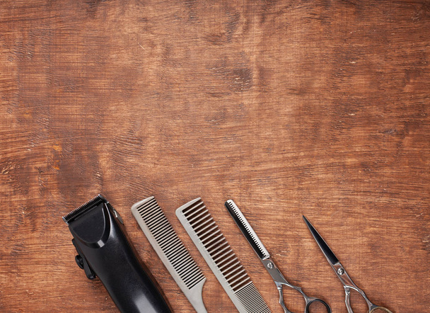 Herramientas para cortar cortes de pelo en peluquería sobre un fondo oscuro. Una maquinilla de afeitar peligrosa, una máquina de escribir, una cortadora de pelo
. - Foto, imagen