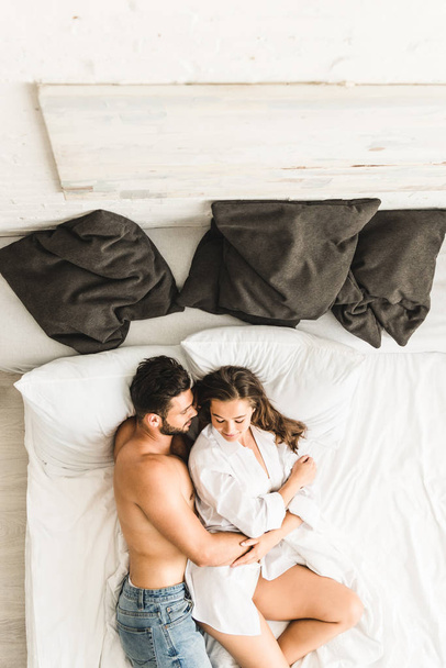 Сон обнимать мальчика. Обнимает в постели. Фотосессия на кровати сверху. Парень обнимает девушку в кровати. Мужчина и женщина лежат в кровати.