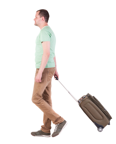 back view of walking man with suitcase. brunette guy in motio - Valokuva, kuva