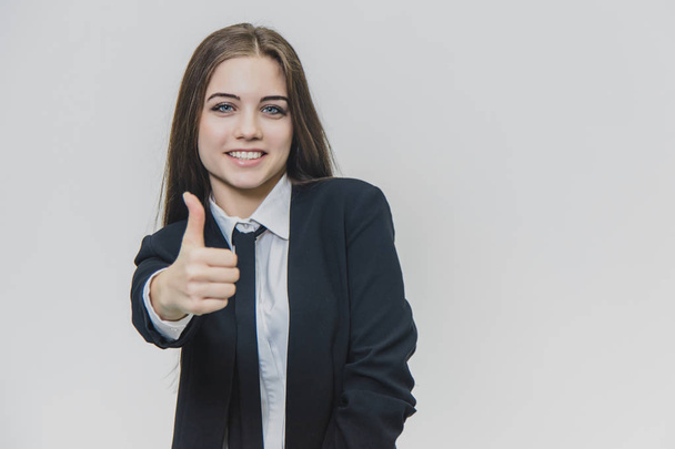 Vrouwelijke handgebaren duim omhoog. Business Girl glimlacht breed en deelt positieve emoties. - Foto, afbeelding