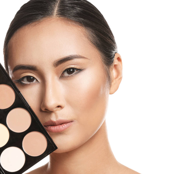 asiatische Frau mit Kosmetika zum Konturieren von Make-up auf weißem Hintergrund - Foto, Bild