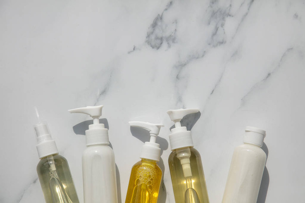 Cosmetics product bottles with natural oils and lotions on a marble background - Foto, Imagen
