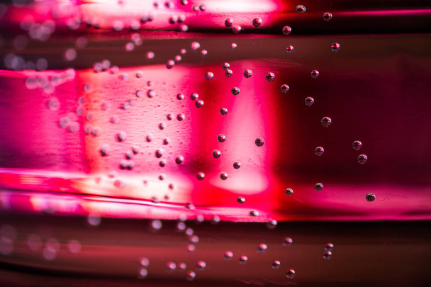 Kleine luchtbellen focus en Unfocus geschorst in water met roze achtergrond - Foto, afbeelding