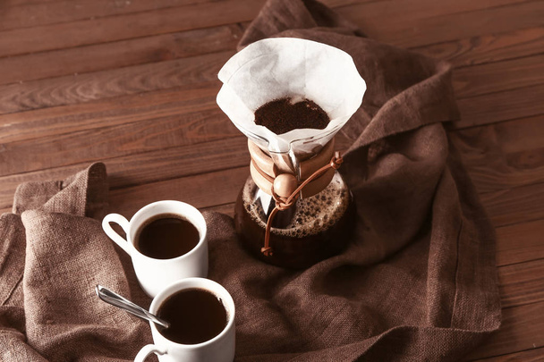 Caffè saporito in chemex e tazze sul tavolo di legno
 - Foto, immagini