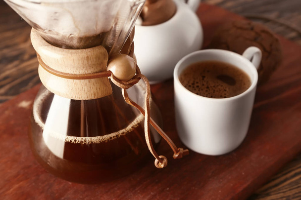 Смачна кава в шампуні і чашка на дерев'яній дошці
 - Фото, зображення