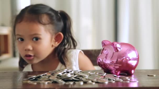 かわいい女の子が自宅の貯金にコインを入れ - 映像、動画