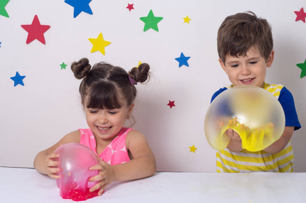 As crianças inflam uma grande bolha de um lodo. Menina e menino jogar com lodo. - Foto, Imagem
