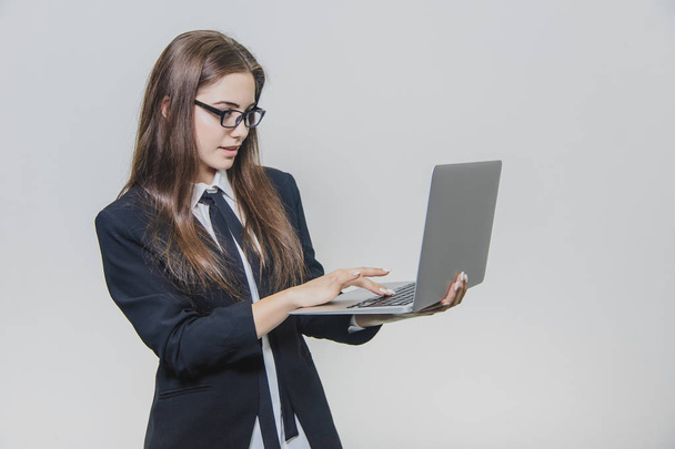 Beautiful young businesswoman is wearing glasses and using a modern computer touchscreen. Confident female employer is working and is concentrated. - 写真・画像