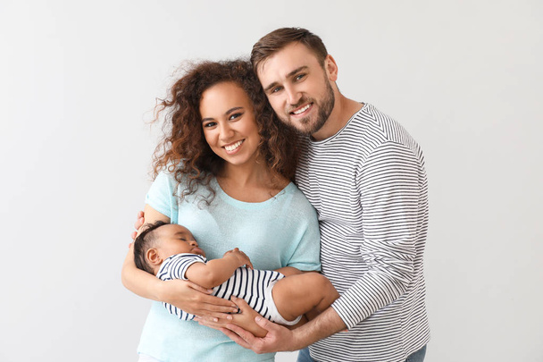 Portrait of happy interracial family on light background - Photo, Image