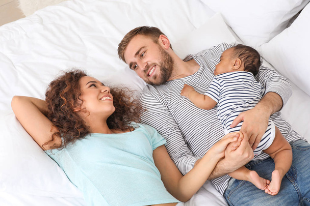 Retrato de familia interracial feliz en el dormitorio
 - Foto, imagen