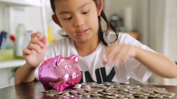 Sevimli kız evde piggy banka para koyarak - Video, Çekim