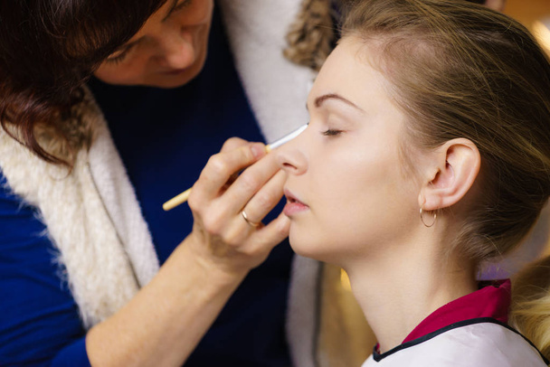 Woman getting eyes make up done by artist - 写真・画像