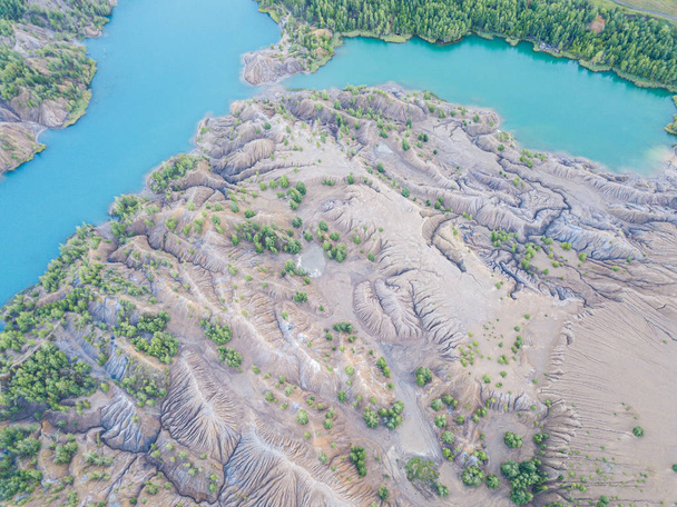 Picturesque air view of the sand pits with single trees and lakes with blue water looks like miniature mountain ridge with valleys and rivers. Konduki, Tula region, Russia. Aerial drone shot. - Фото, изображение
