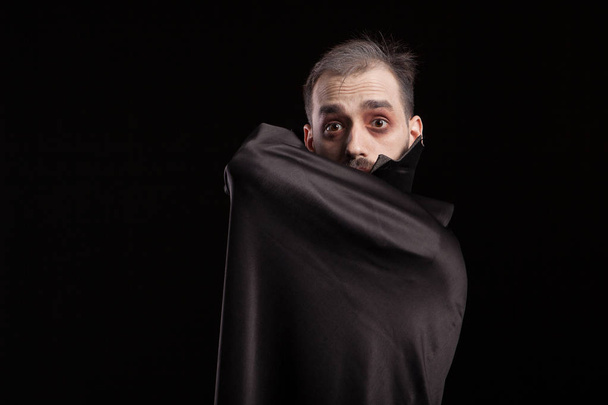 Férfi öltözött fel Drakula jelmez Halloween bujkál behing a köpeny - Fotó, kép