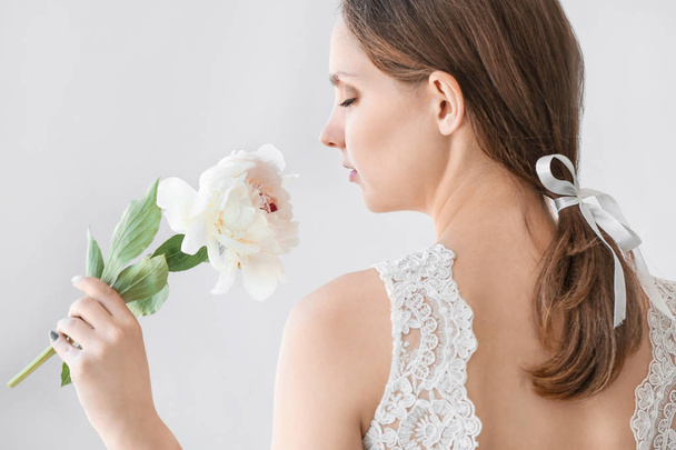 Fiatal menyasszony, gyönyörű bazsarózsa a fény háttér - Fotó, kép