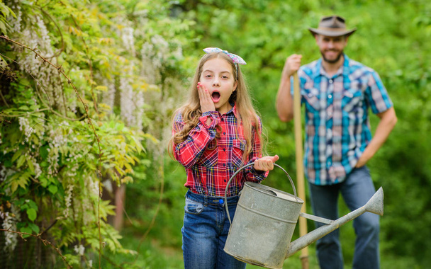 little girl and happy man dad. earth day. family farm. spring village country. father and daughter on ranch. ecology. Watering can and shovel. Beautiful female florist. Passionated about her job - 写真・画像