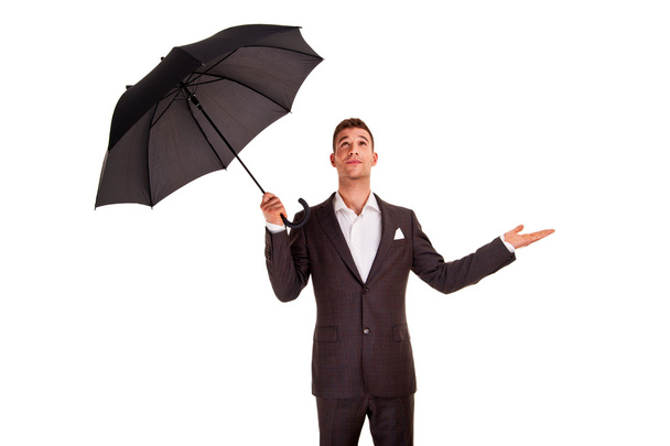 Joven hombre de negocios con un paraguas chequeando la lluvia
 - Foto, imagen