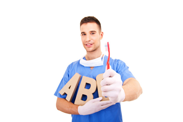 Dentista segurando escova de dentes
 - Foto, Imagem