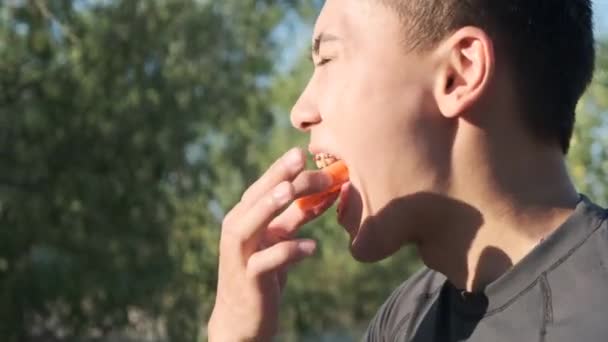 Young boxer preparing for training in the park. Athlete with a mouthpiece. Dental braces - 映像、動画