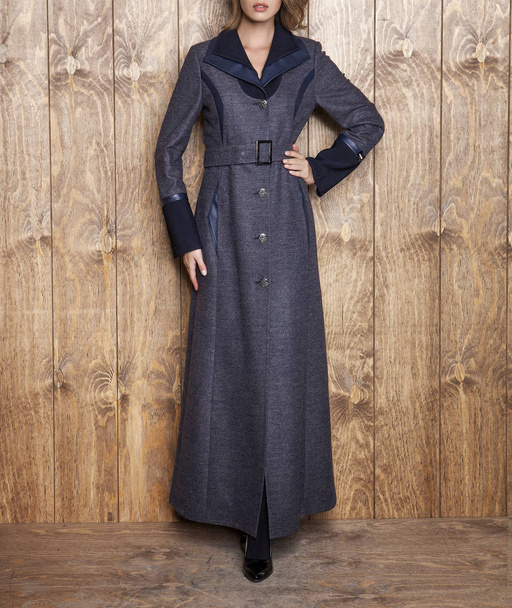 Modello femminile in cappotto grigio alla moda, ripresa in studio
 - Foto, immagini