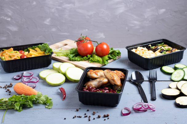 Business Lunch in Lebensmittelboxen, gebratene Chicken Wings, gedünstetes Gemüse, geschmortes Fleisch, Fertiggerichte - Foto, Bild