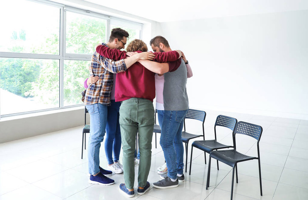 Young people hugging together at group therapy session - Φωτογραφία, εικόνα