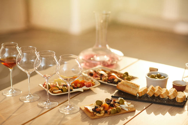 Image de fond de verres à vin sur une table en bois avec des collations rustiques pour la dégustation de vin en plein soleil, espace de copie
 - Photo, image