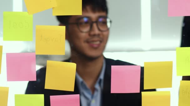Groep van Aziatische creatieve mannen workshop en Brainstorm voor spiegel bord. Young Professional Business team werken strategie, bedrijfssituatie, Startup in Loft Office concept. Slow Motion. - Video