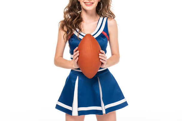 recortado vista de feliz animadora chica en azul uniforme celebración rugby bola aislado en blanco
 - Foto, Imagen
