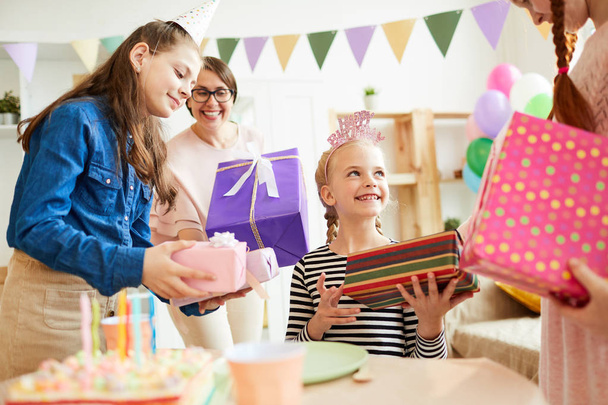 Muotokuva söpö tyttö vastaanottaa lahjoja ympäröivät ystävät aikana syntymäpäiväjuhlat, kopioi tilaa
 - Valokuva, kuva