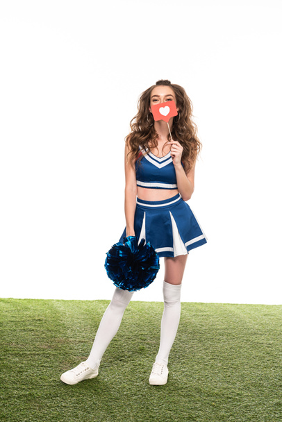 cheerleader girl in blue uniform with like sign and pompom on green field isolated on white - Foto, Imagen