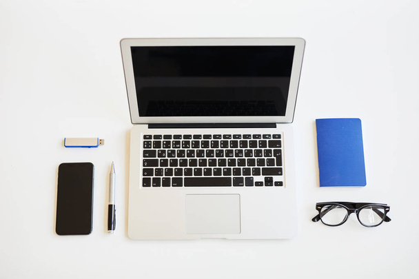 Vista de ángulo alto de artículos de negocios como diario, lápiz y anteojos y dispositivos portátiles modernos en la mesa blanca
 - Foto, imagen