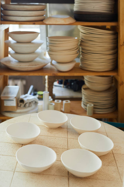 Imagen de fondo de cuencos de porcelana en la mesa en estudio artesanal, espacio de copia
 - Foto, Imagen