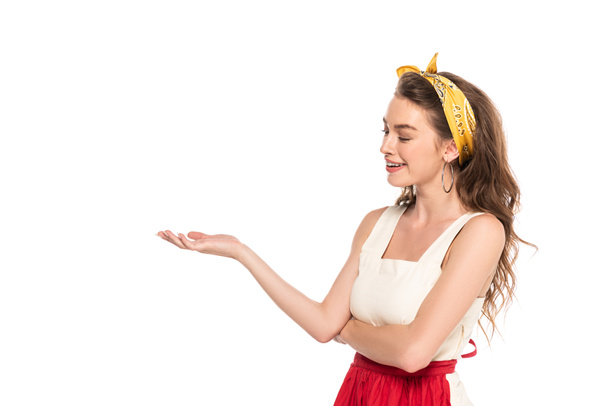 young happy housewife in dress and apron pointing with hand isolated on white - Φωτογραφία, εικόνα