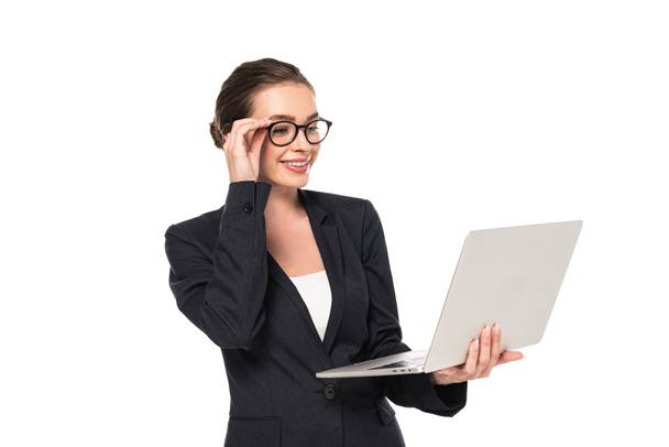 młody szczęśliwy kobieta interesu w garniturze i okulary trzymając laptop na białym tle - Zdjęcie, obraz