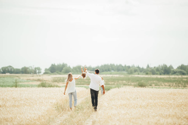 Šťastné rodinné procházky v pšeničném poli za slunečného dne - Fotografie, Obrázek