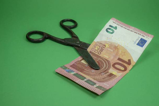 Ψαλίδι περικοπή τραπεζογραμματίων ευρώ σε πράσινο φόντο - Φωτογραφία, εικόνα