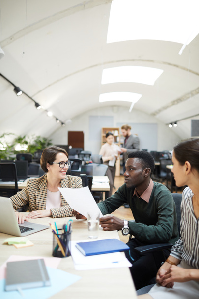 Багатонаціональна група людей обговорює роботу під час співпраці в офісі, копіює простір
 - Фото, зображення