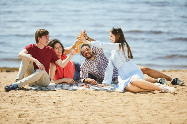 Ολόσωμο πορτρέτο της ομάδας των φίλων απολαμβάνοντας πικνίκ στην παραλία το καλοκαίρι, αντίγραφο χώρου - Φωτογραφία, εικόνα