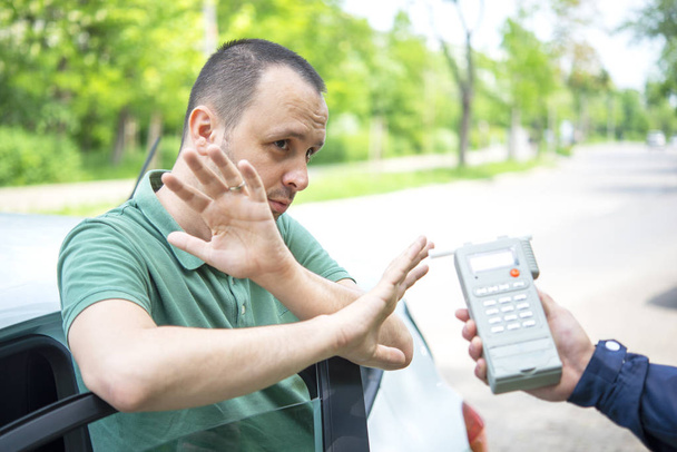 Alkoholipitoisuuden testauksen kohteena oleva kuljettaja, joka käyttää puhallustinta
 - Valokuva, kuva