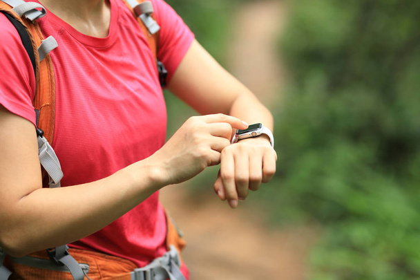 Woman hiker checking on smartwatch on hiking travel   - Fotoğraf, Görsel
