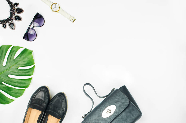 Vista aérea del conjunto de accesorios de moda femenina aislados sobre fondo blanco. Vista superior del bolso de cuero, zapatos, gafas de sol y reloj
. - Foto, Imagen