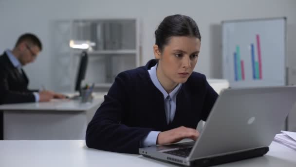 Vrouwelijke manager aandachtig lezen van documenten op laptop, zoeken naar fout - Video