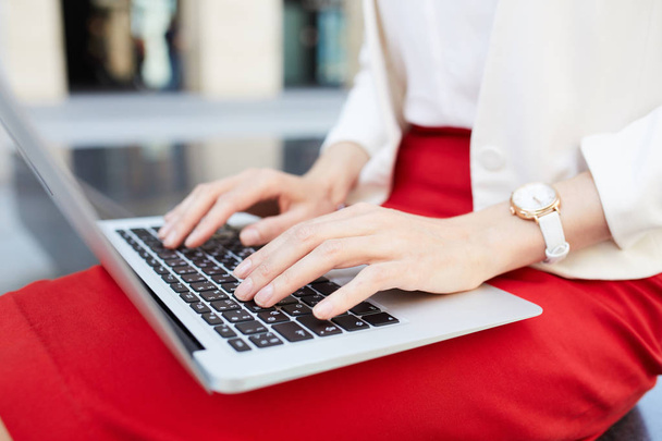 Close-up de empresária irreconhecível digitando no teclado do laptop enquanto trabalhava ao ar livre, espaço de cópia
 - Foto, Imagem
