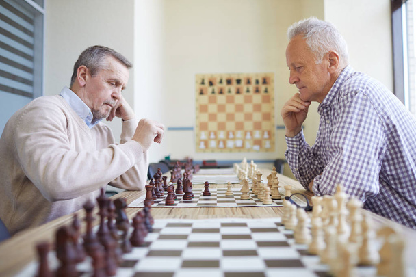 Deux joueurs d'échecs expérimentés âgés avec des cheveux argentés jouant aux échecs au tournoi d'échecs professionnel
 - Photo, image
