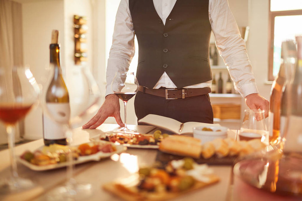 Portrait de milieu de section de sommelier méconnaissable debout à table pendant la dégustation de vin, espace de copie
 - Photo, image