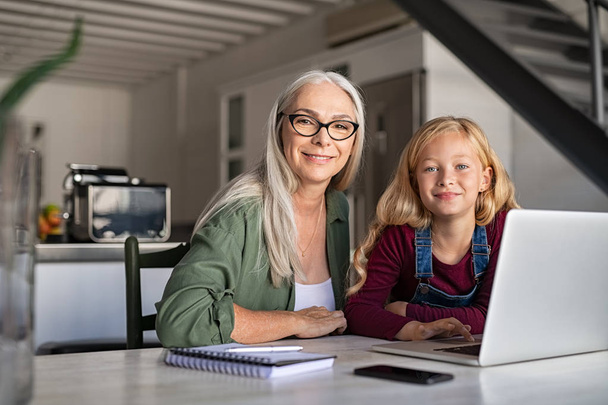 Happy granny and smiling little girl study at home - Foto, Imagen