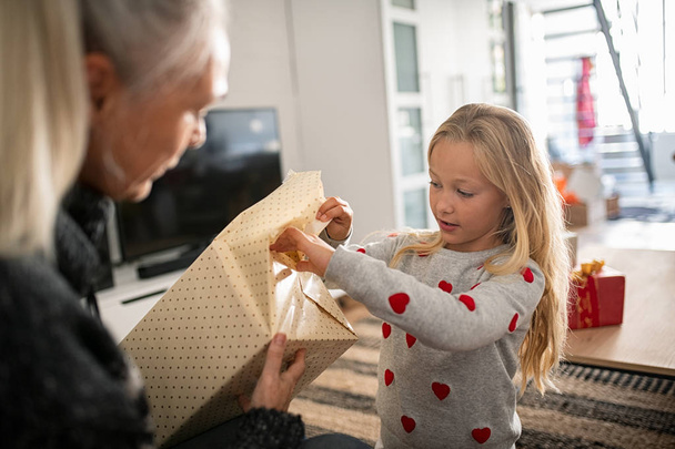 Girl unwrapping present for birthday - Photo, Image