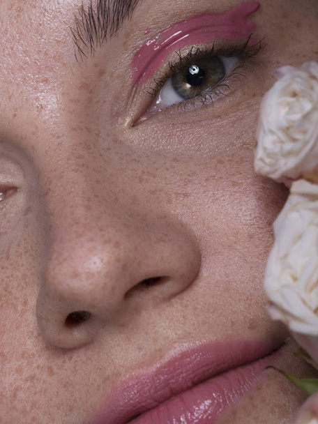 Jolie femme brune avec maquillage créatif rose et eustoma ros
 - Photo, image