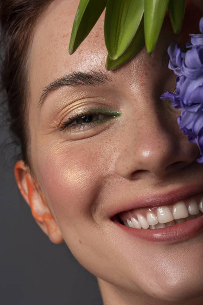 Pěkná brunetka s červeným kreativním make-up a modrou hyacint - Fotografie, Obrázek